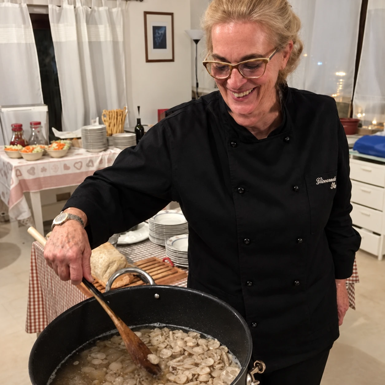 Giovannella sorride mentre mescola una preparazione in padella