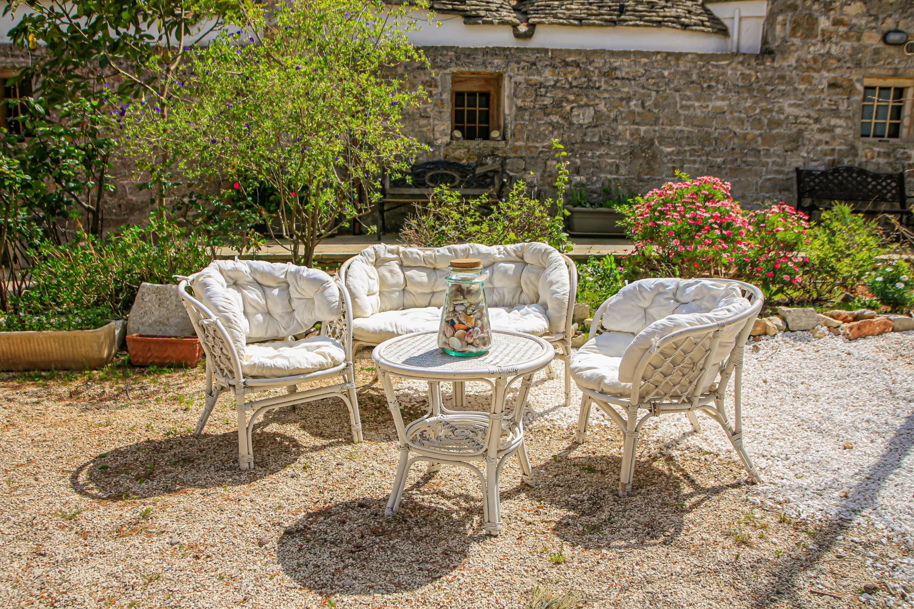 The masseria’s stone façade with wicker seating and geraniums